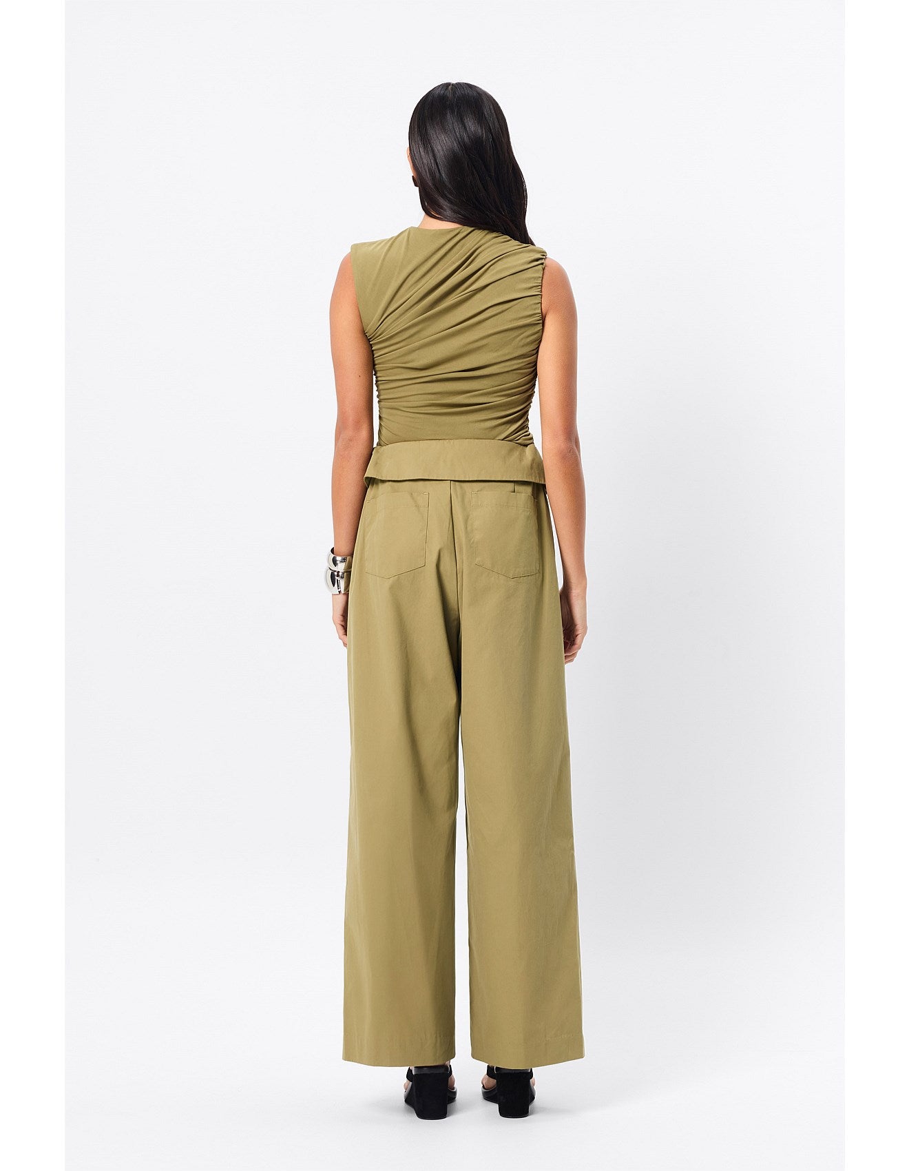 Woman standing in an olive top.
A sleek essential with a sculptural edge, the Sole Purpose Tank in Black brings modern ease to everyday dressing. Cut from a soft stretch jersey fabrication, this sleeveless style features gathered detailing through the sides and bodice, creating a flattering, body-skimming silhouette. Designed with a high round neckline and half lining through the body, it delivers both comfort and structure. Pair back with tailoring or relaxed separates for effortless sophistication.