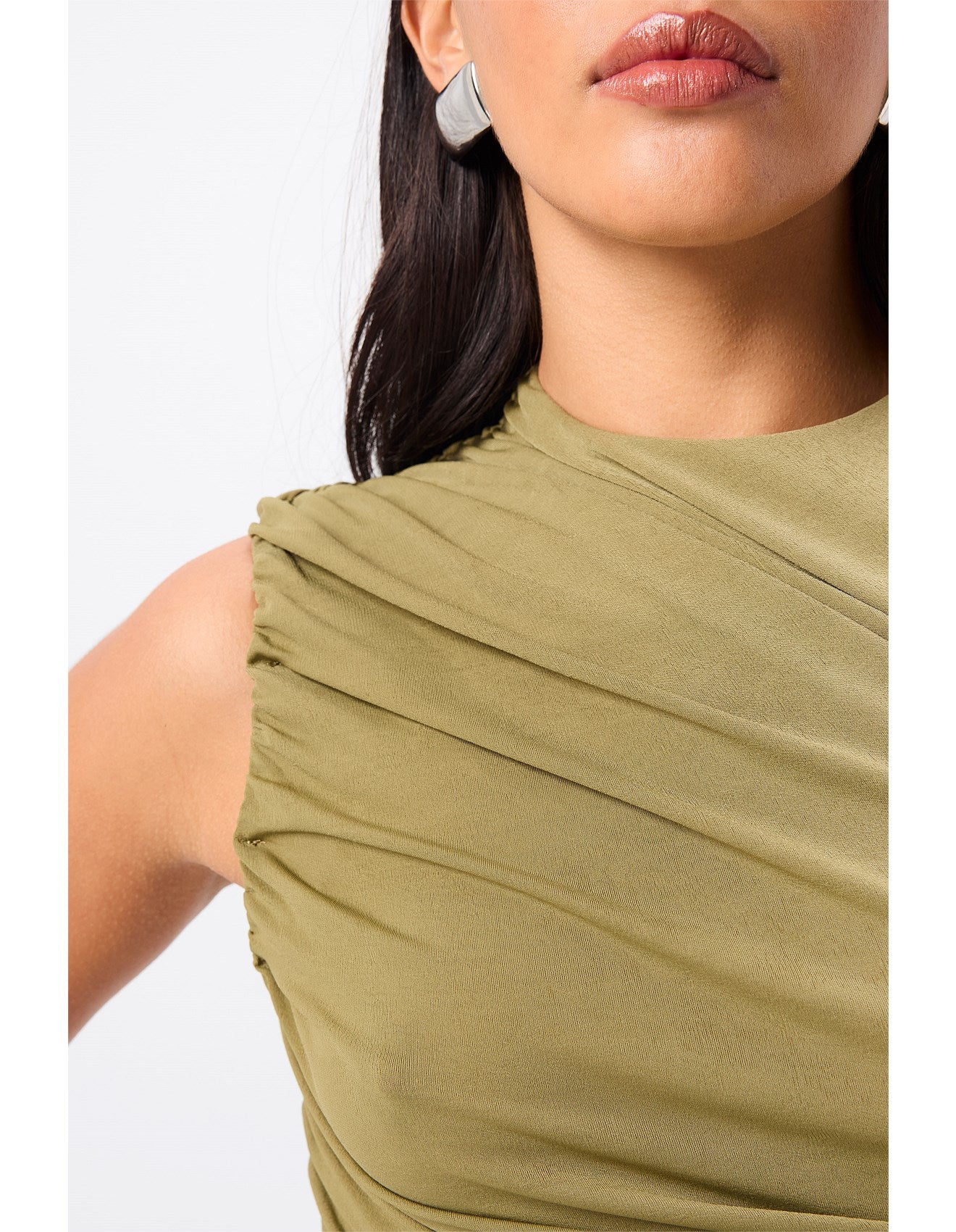 Woman standing in an olive top.
A sleek essential with a sculptural edge, the Sole Purpose Tank in Black brings modern ease to everyday dressing. Cut from a soft stretch jersey fabrication, this sleeveless style features gathered detailing through the sides and bodice, creating a flattering, body-skimming silhouette. Designed with a high round neckline and half lining through the body, it delivers both comfort and structure. Pair back with tailoring or relaxed separates for effortless sophistication.