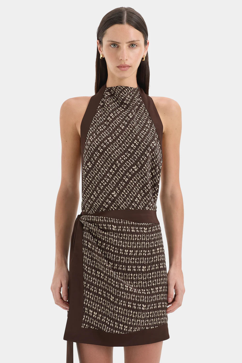 Woman wearing a brown patterned dress on a white background
