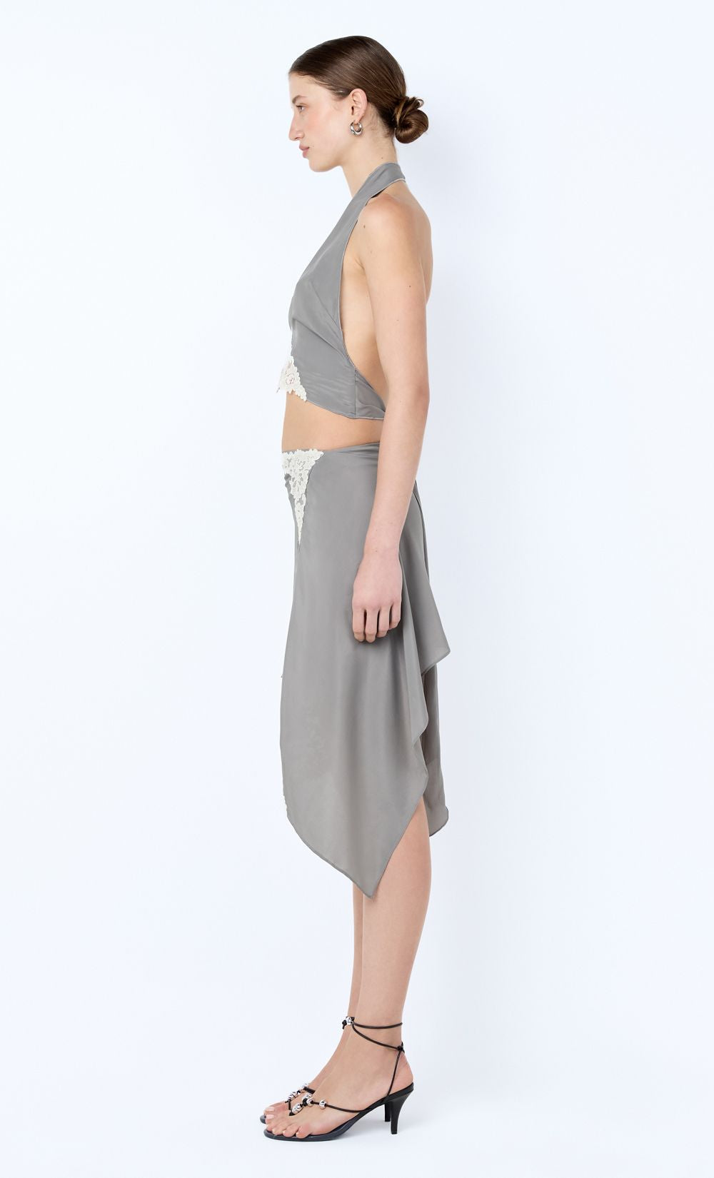 Woman wearing a gray halter top and skirt set on a white background