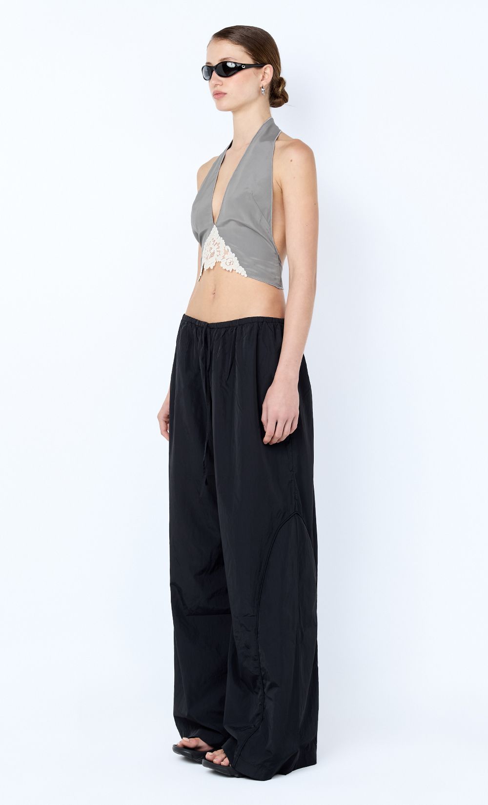 Woman wearing a halter top and wide-leg pants on a white background