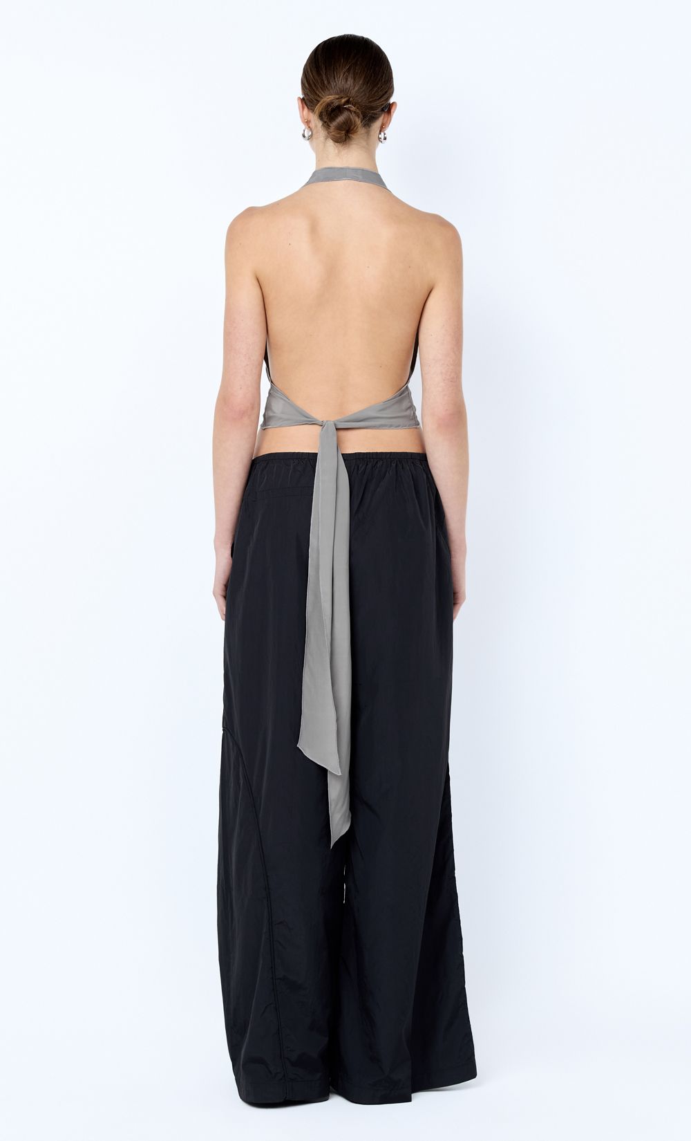 Woman wearing a black dress with a gray belt on a white background