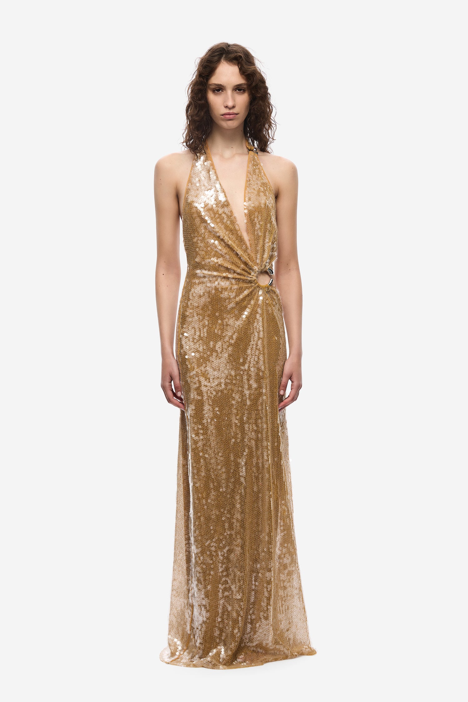 Woman wearing a gold sequin dress on a white background