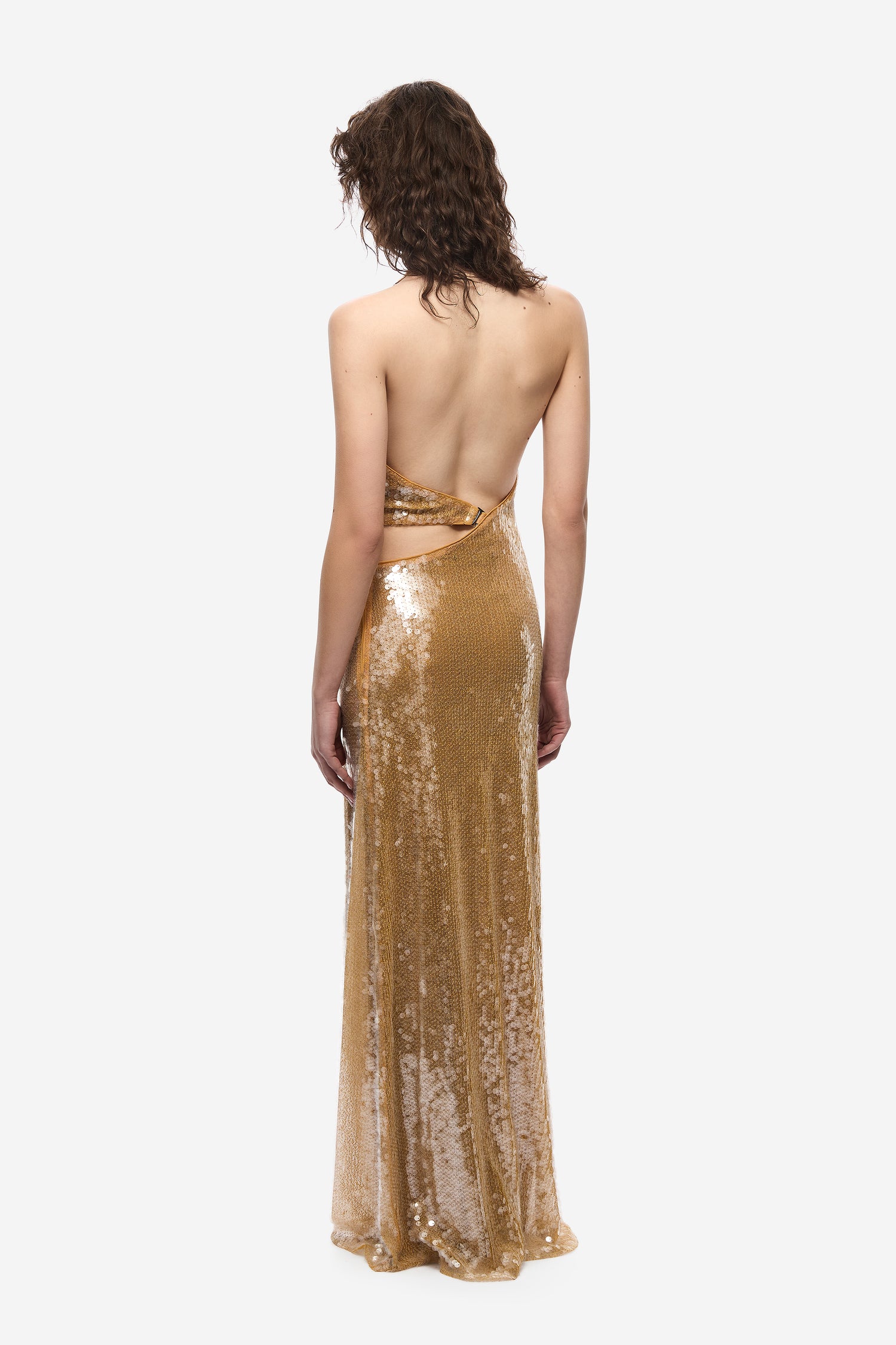 Woman wearing a gold sequin dress on a white background