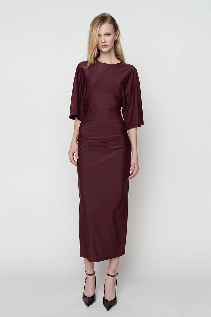 Woman wearing a burgundy dress on a white background