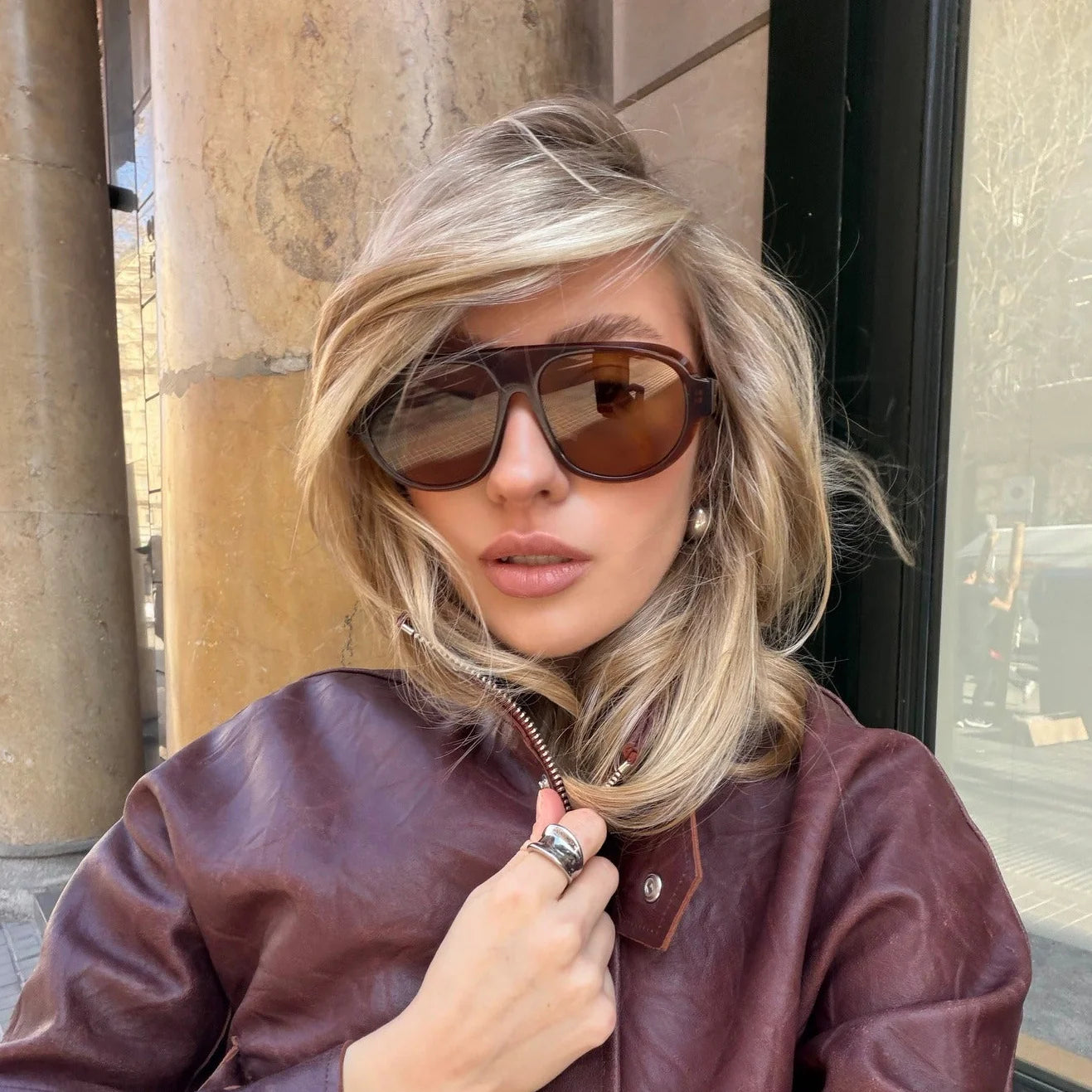 Brown Aviator Sunglasses on a woman wearing a cool bomber jacket and blonde hair