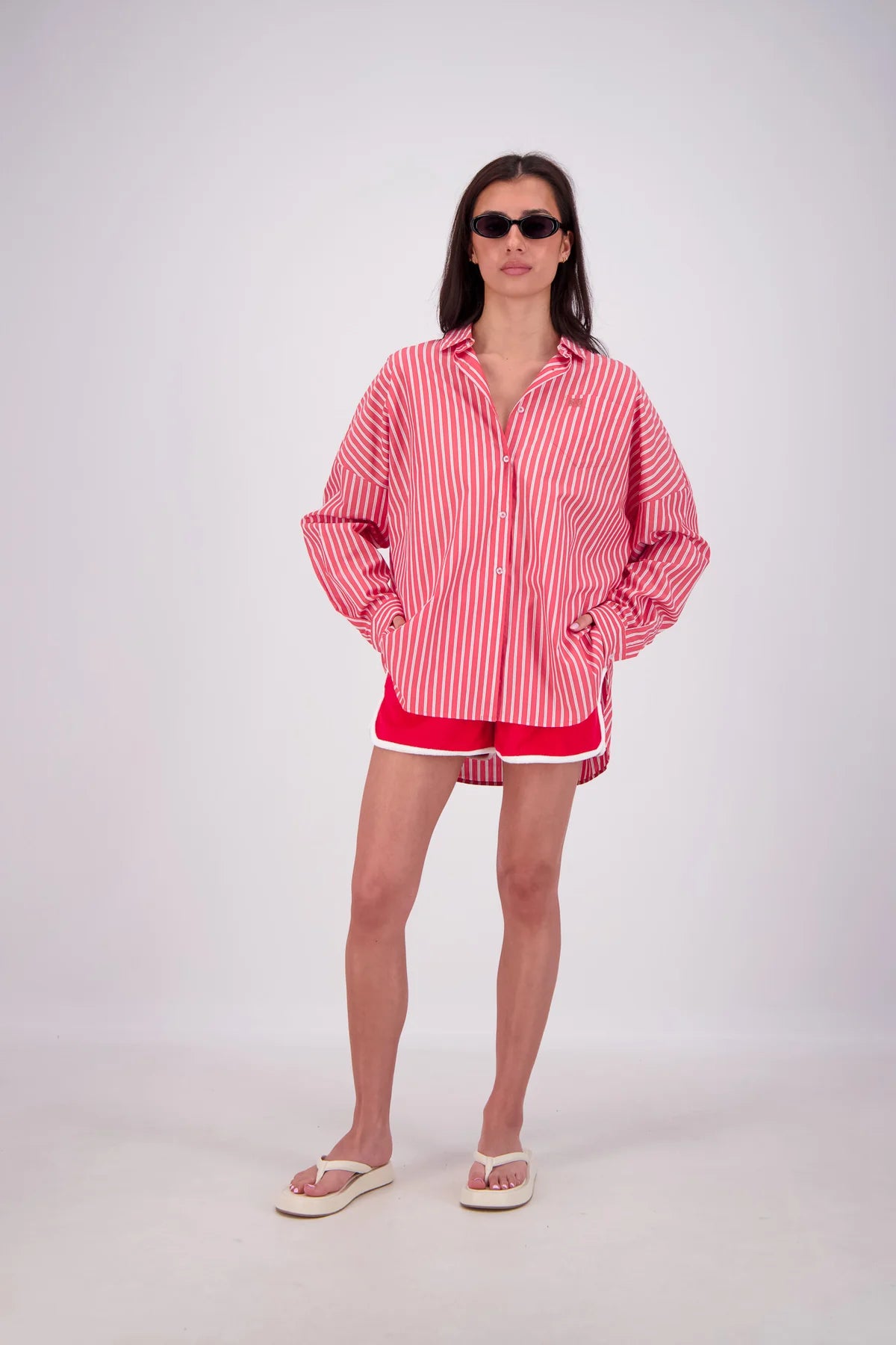 Person wearing a red and white striped shirt and shorts on a white background