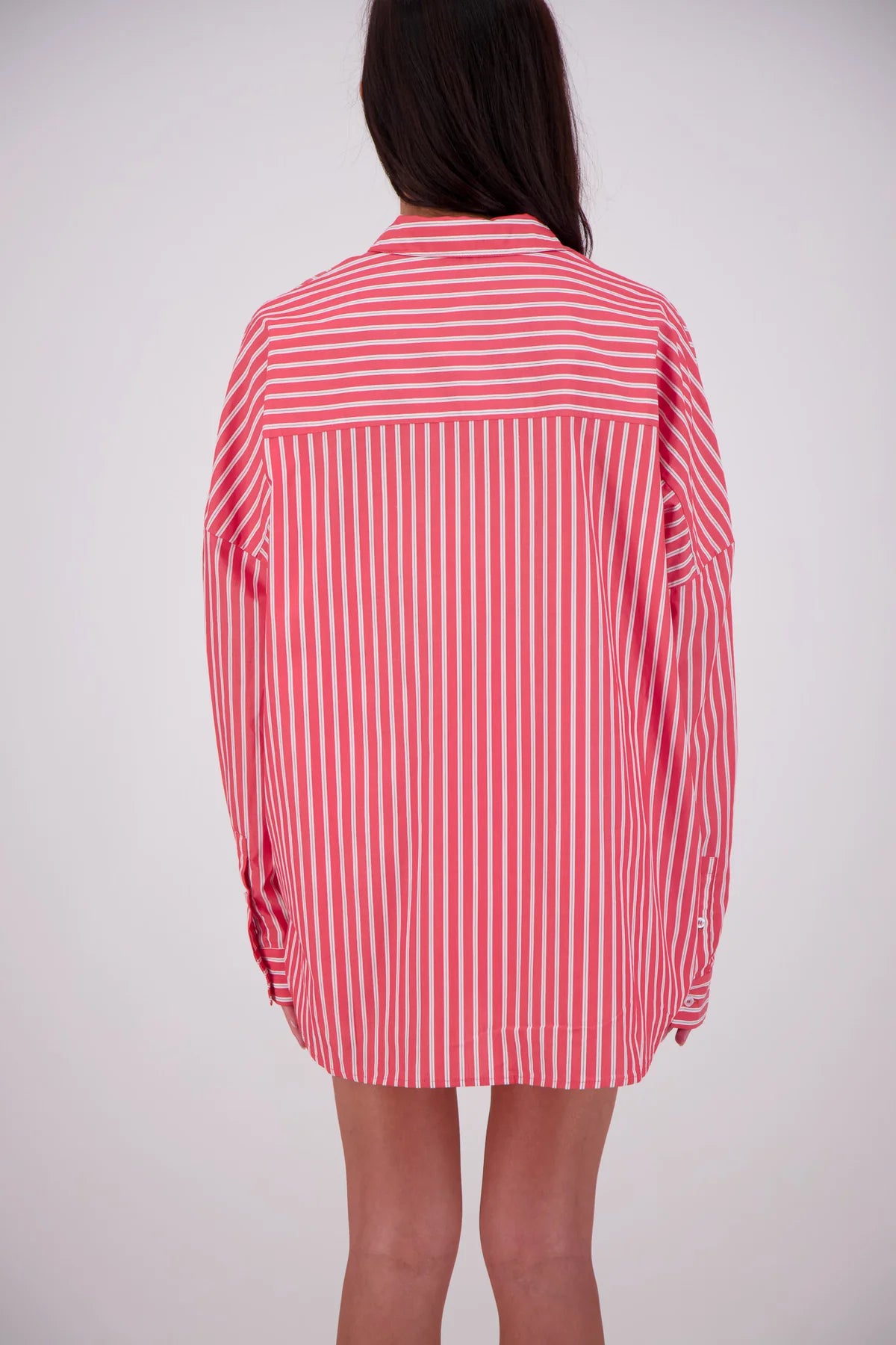 Red and white striped shirt worn by a person on a plain background