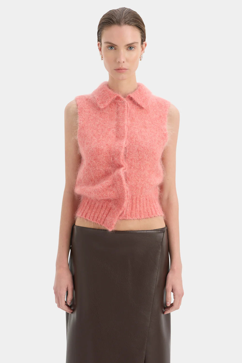 Woman wearing a pink knitted vest on a white background