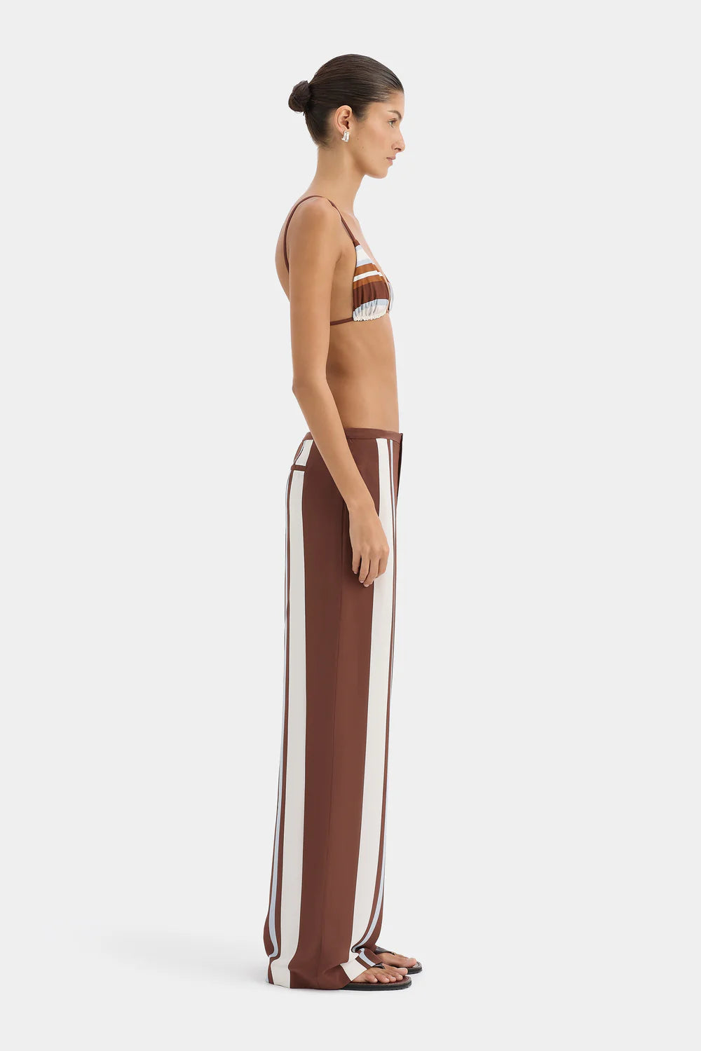 Woman wearing a brown and white striped outfit on a white background