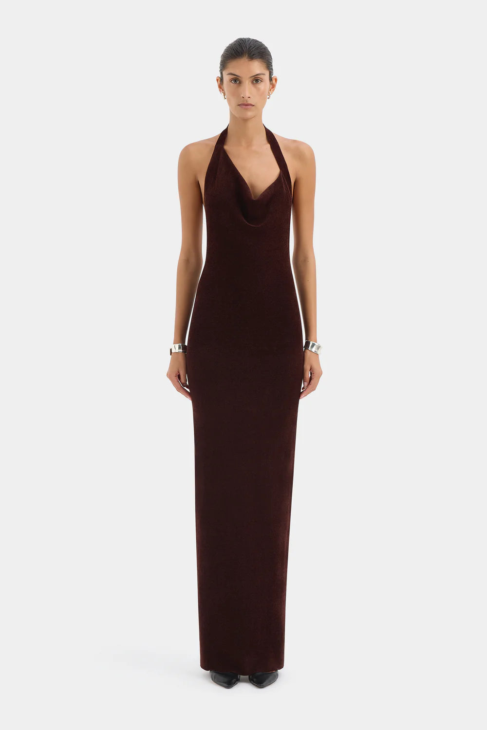 Woman wearing a brown halter neck dress on a white background