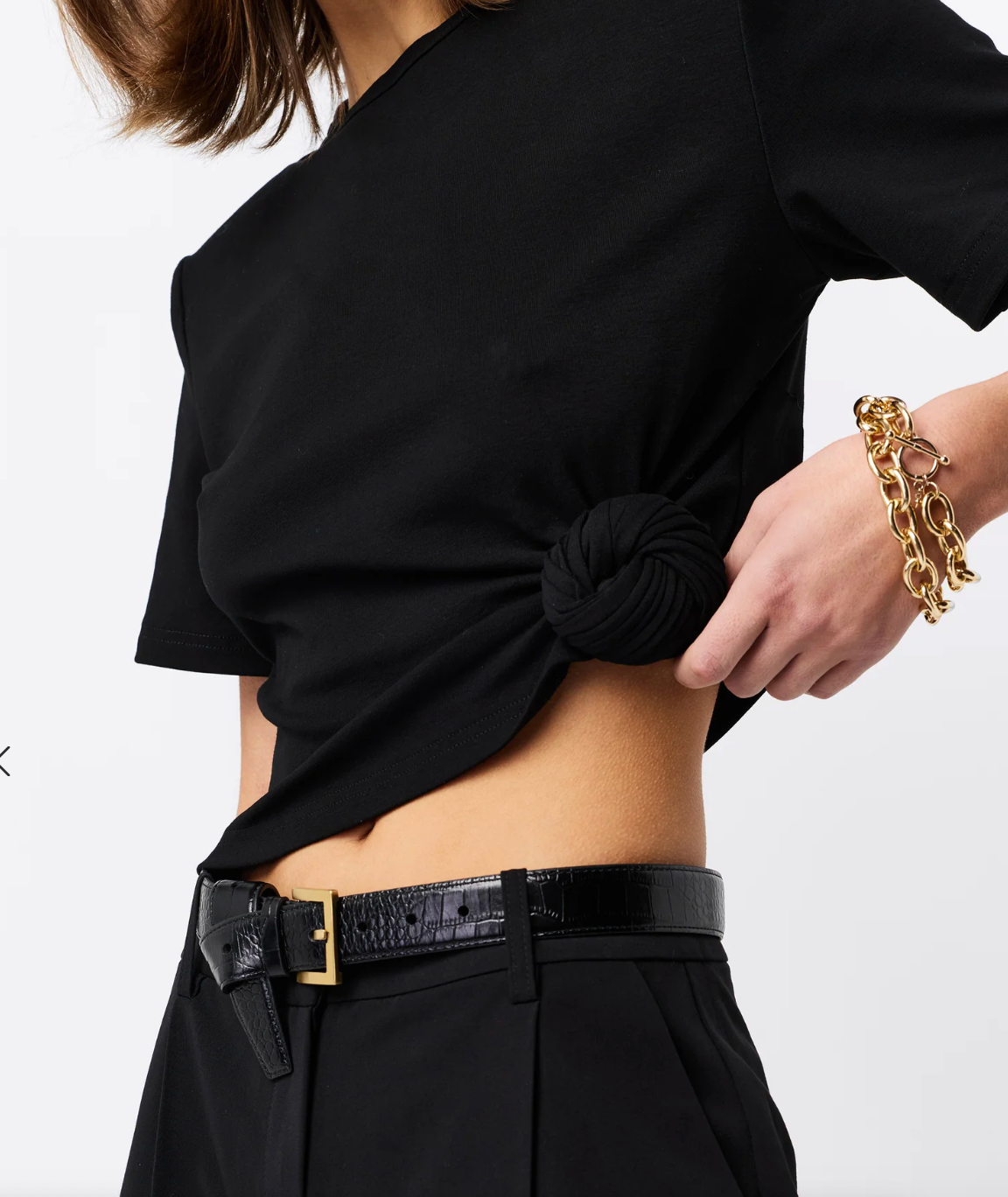 Woman wearing a black Fashion Tshirt with shoulder pads with a white background