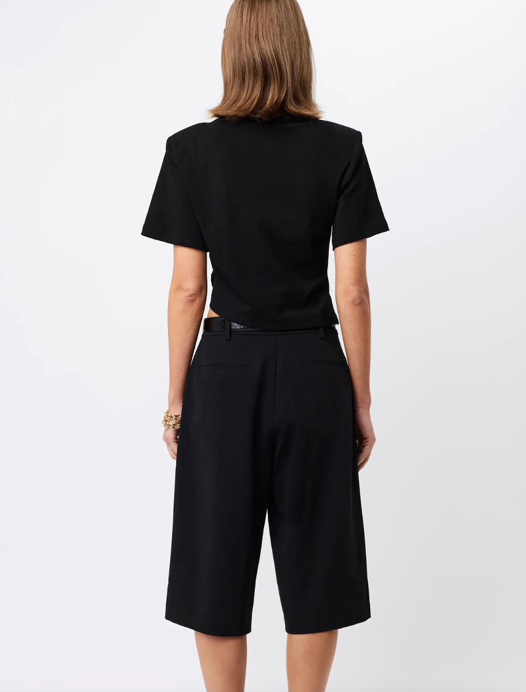 Woman wearing a black Fashion Tshirt with shoulder pads with a white background