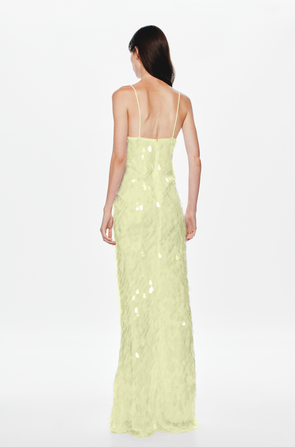Woman in a lemon sequin dress on a white background