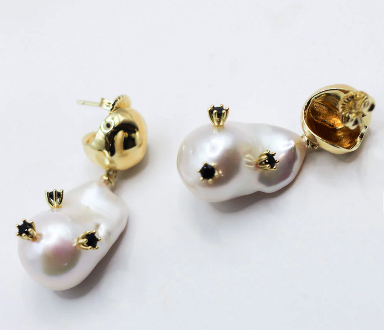 Pearl earrings with gold accents on a white background