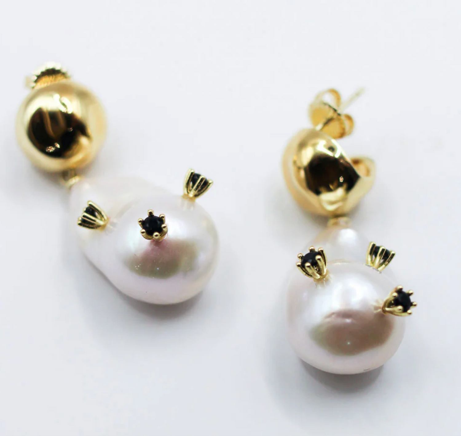 Pearl earrings with gold accents on a white background