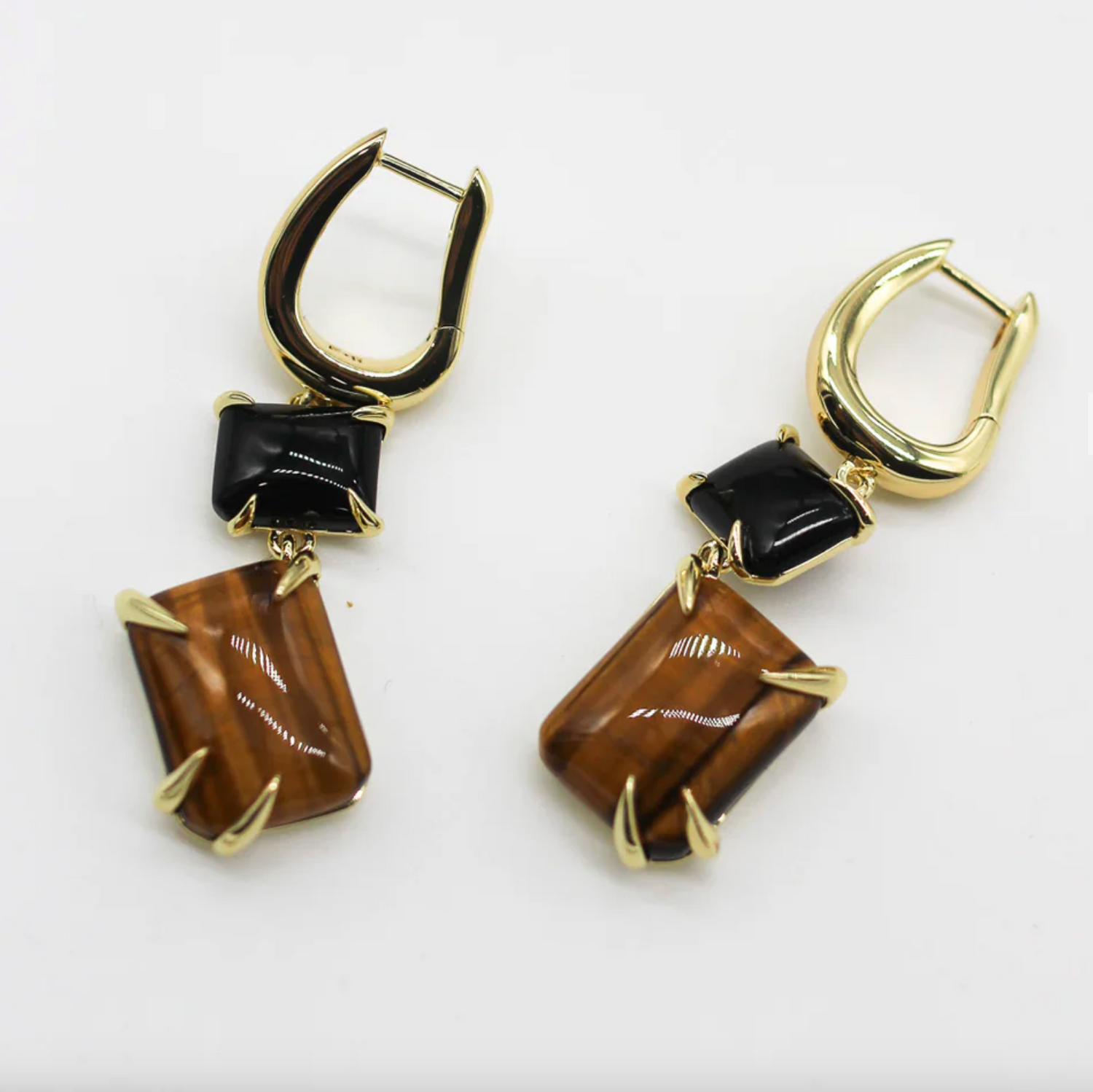 Gold and brown earrings on a white background