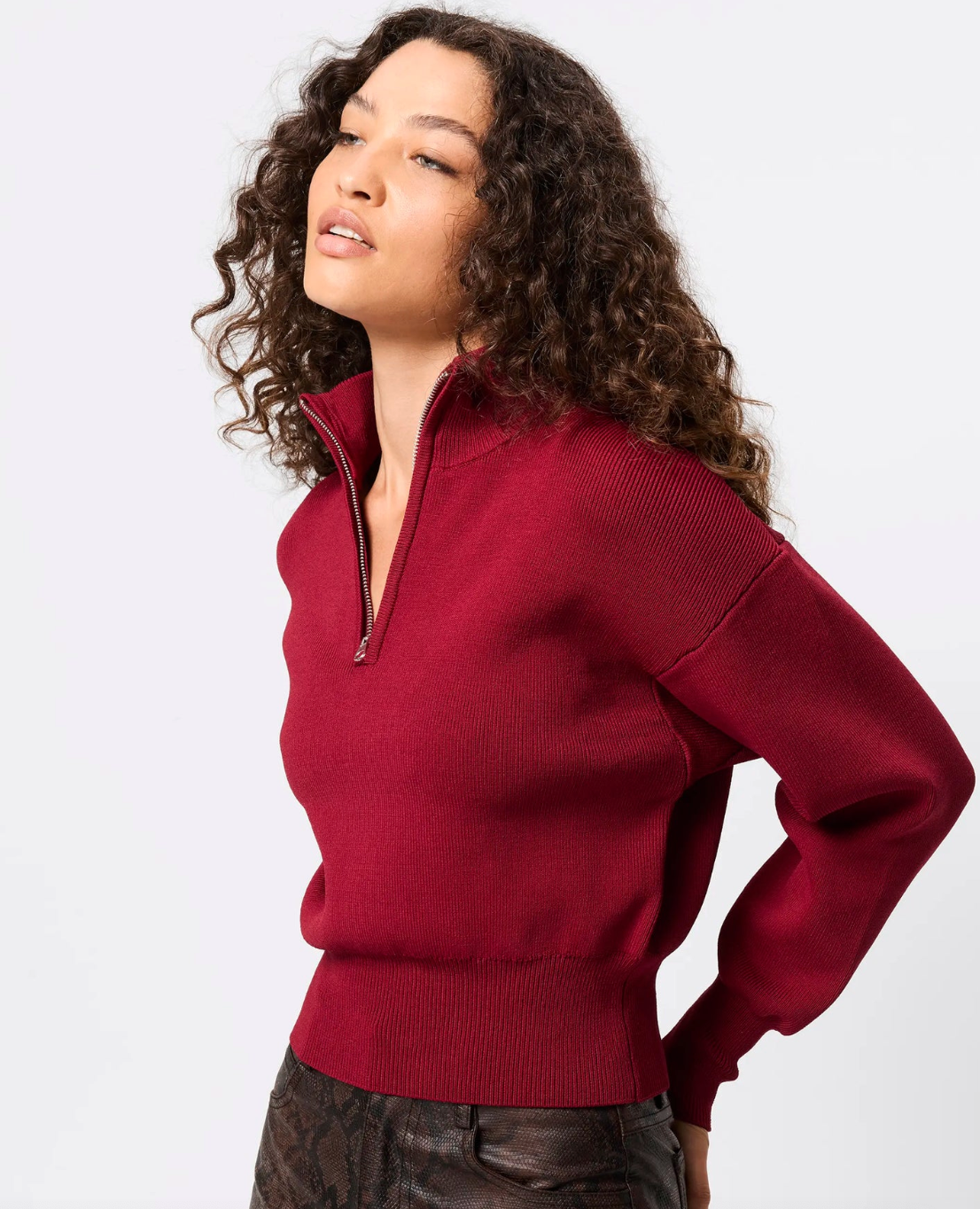 Woman wearing a red sweater against a white background