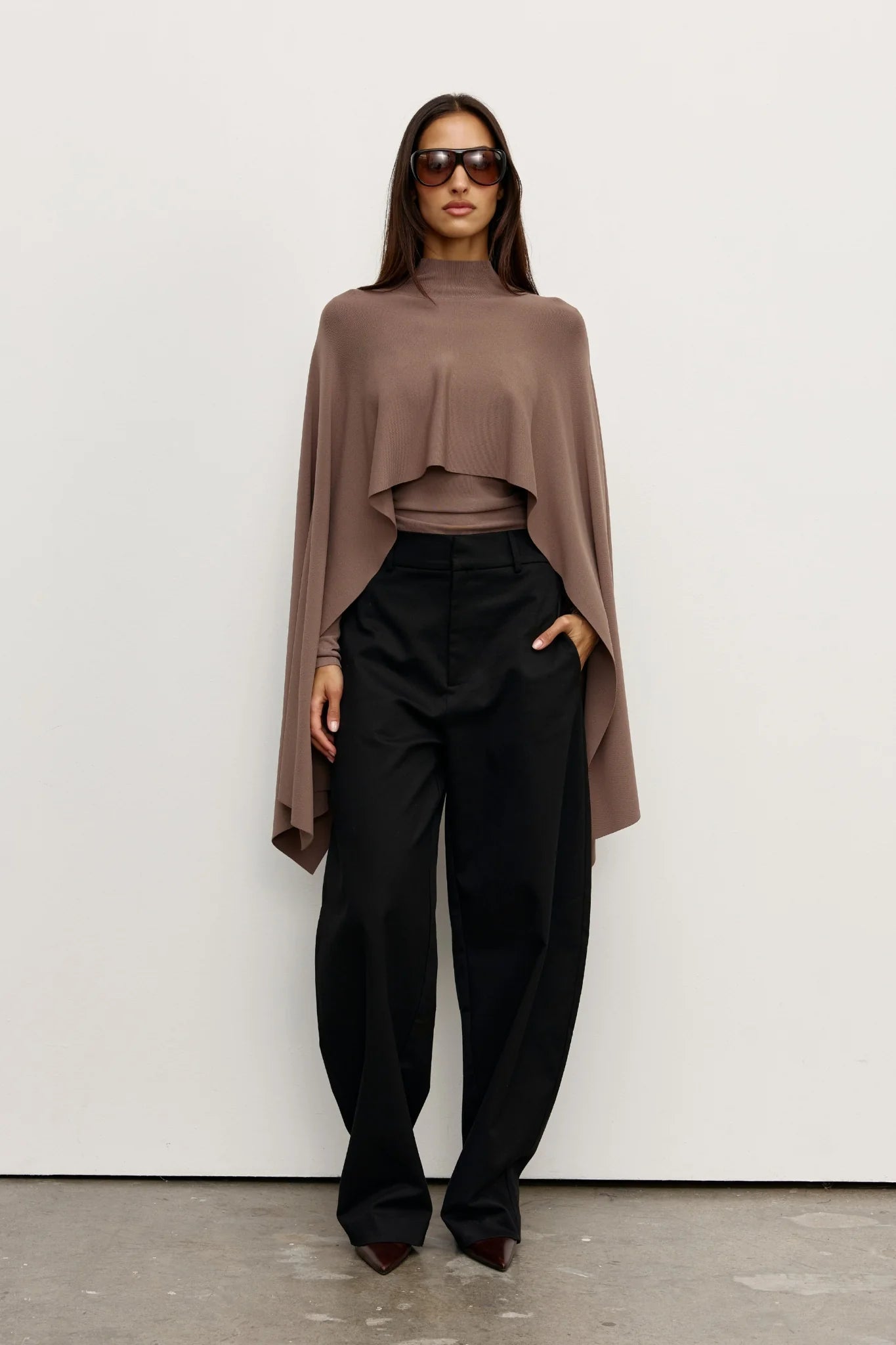 A brown poncho on a woman with black pants