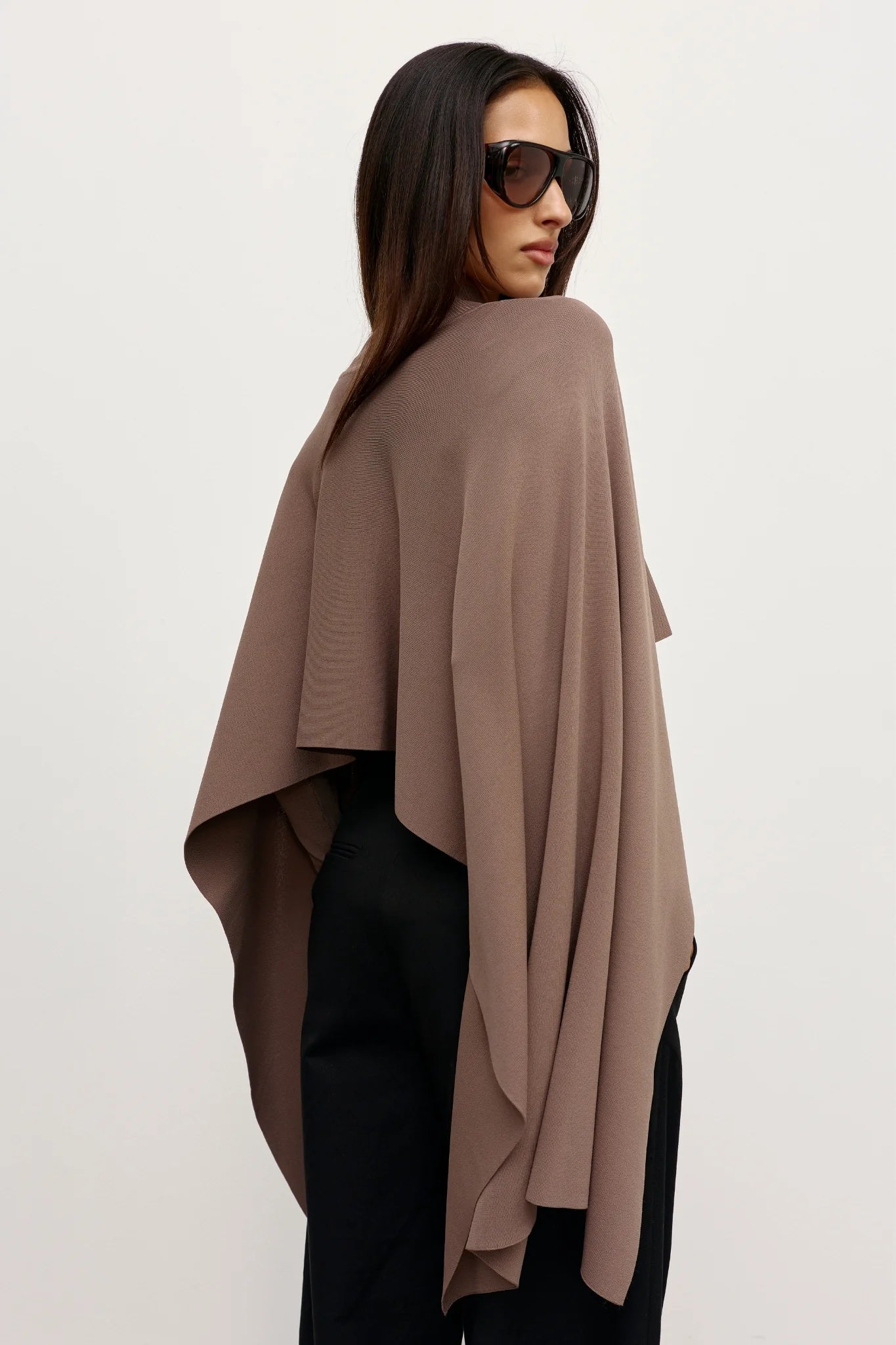 A brown poncho on a woman with black pants