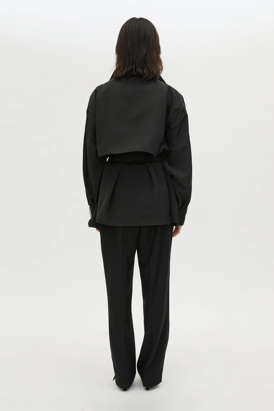 Person wearing a black suit on a white background
