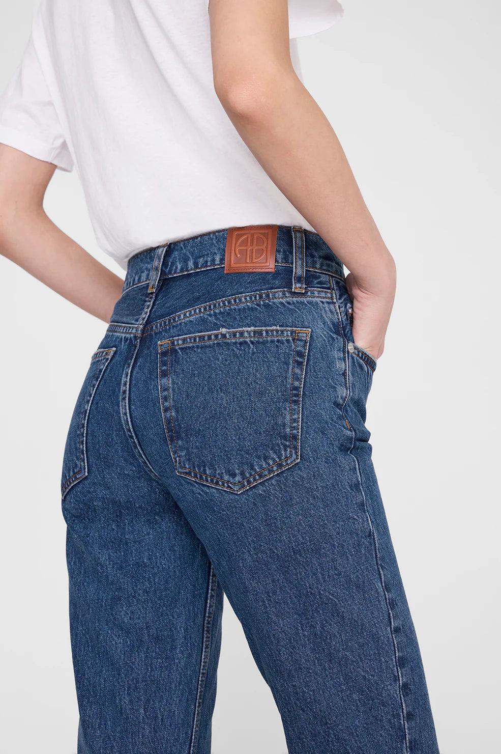 Person wearing blue jeans with a white background