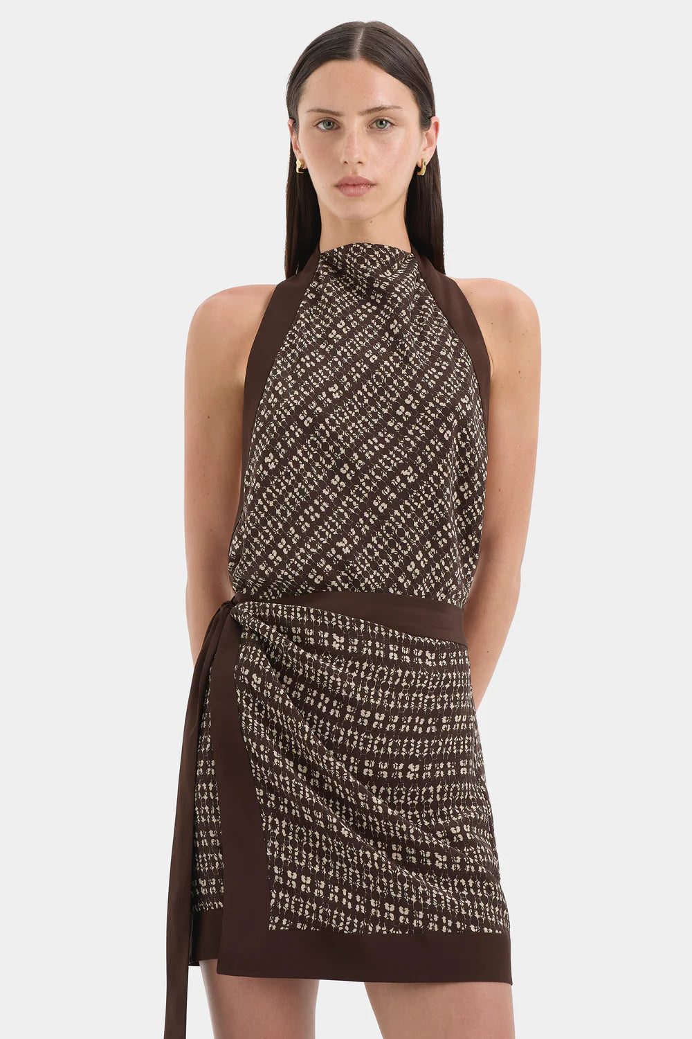 Woman wearing a patterned dress with a plain background