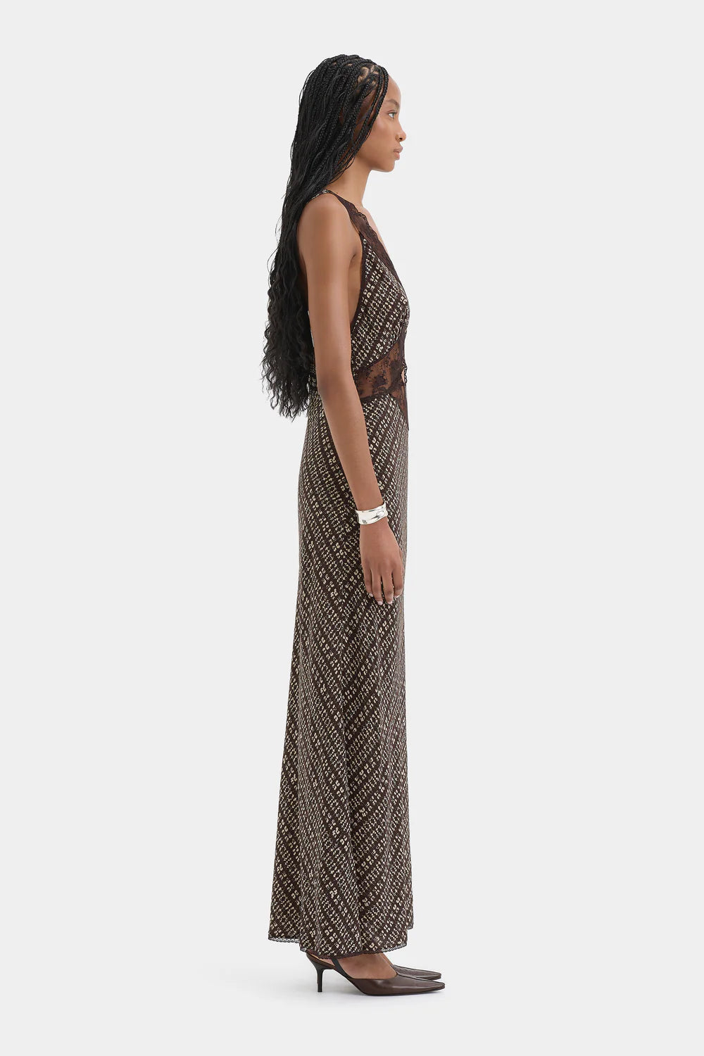Woman wearing a long, patterned dress on a white background