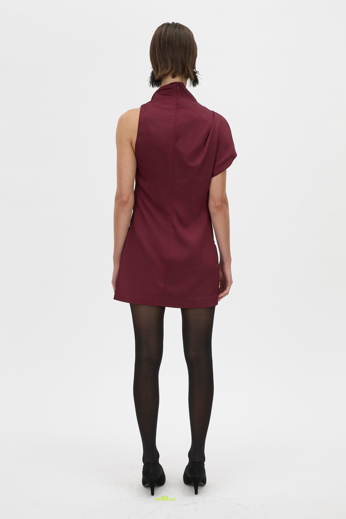 Person wearing a burgundy dress on a white background