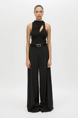 Woman wearing a black sleeveless top and wide-leg pants on a white background