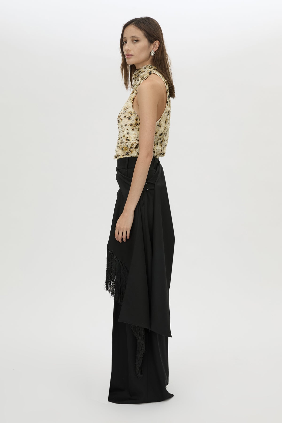 Woman wearing a patterned top and black skirt on a white background