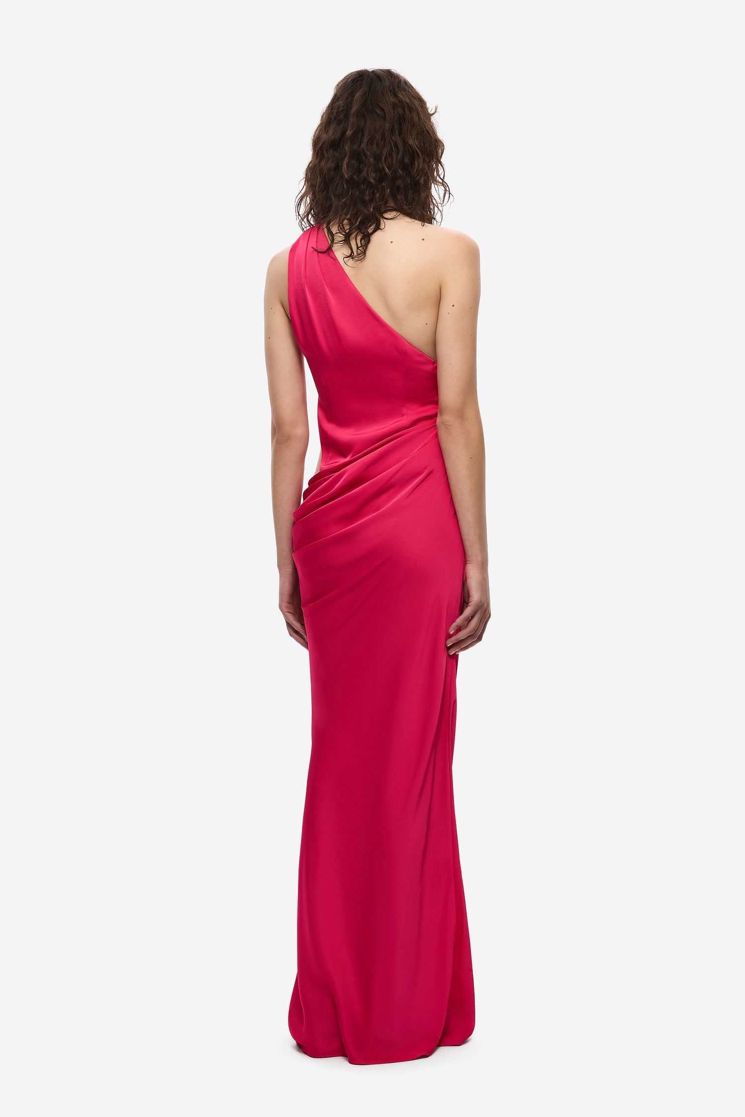 Woman wearing a pink one-shoulder dress on a white background