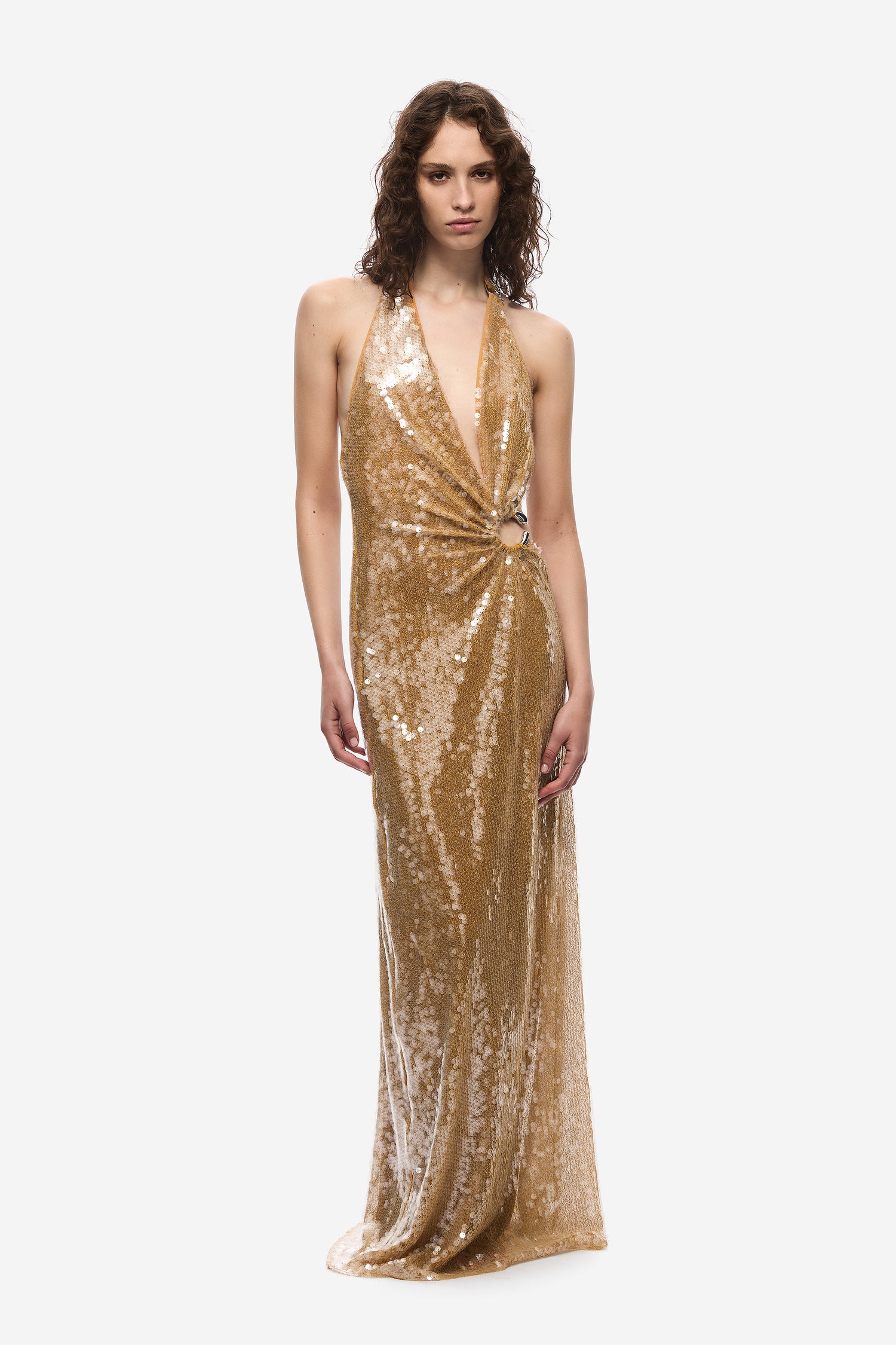 Woman wearing a gold sequin gown on a white background