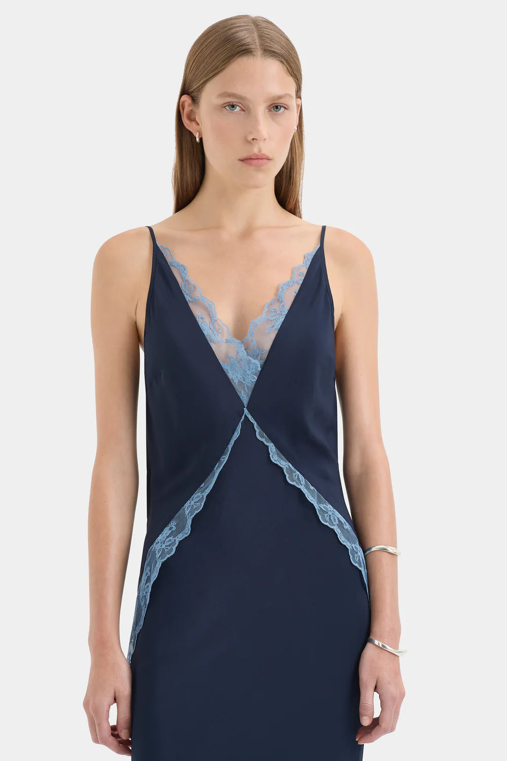 Navy blue slip dress with lace trim worn by a model on a white background