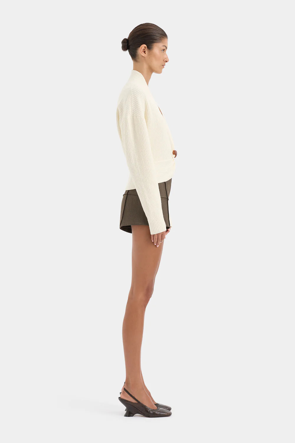 Woman wearing a white sweater and black skirt on a white background