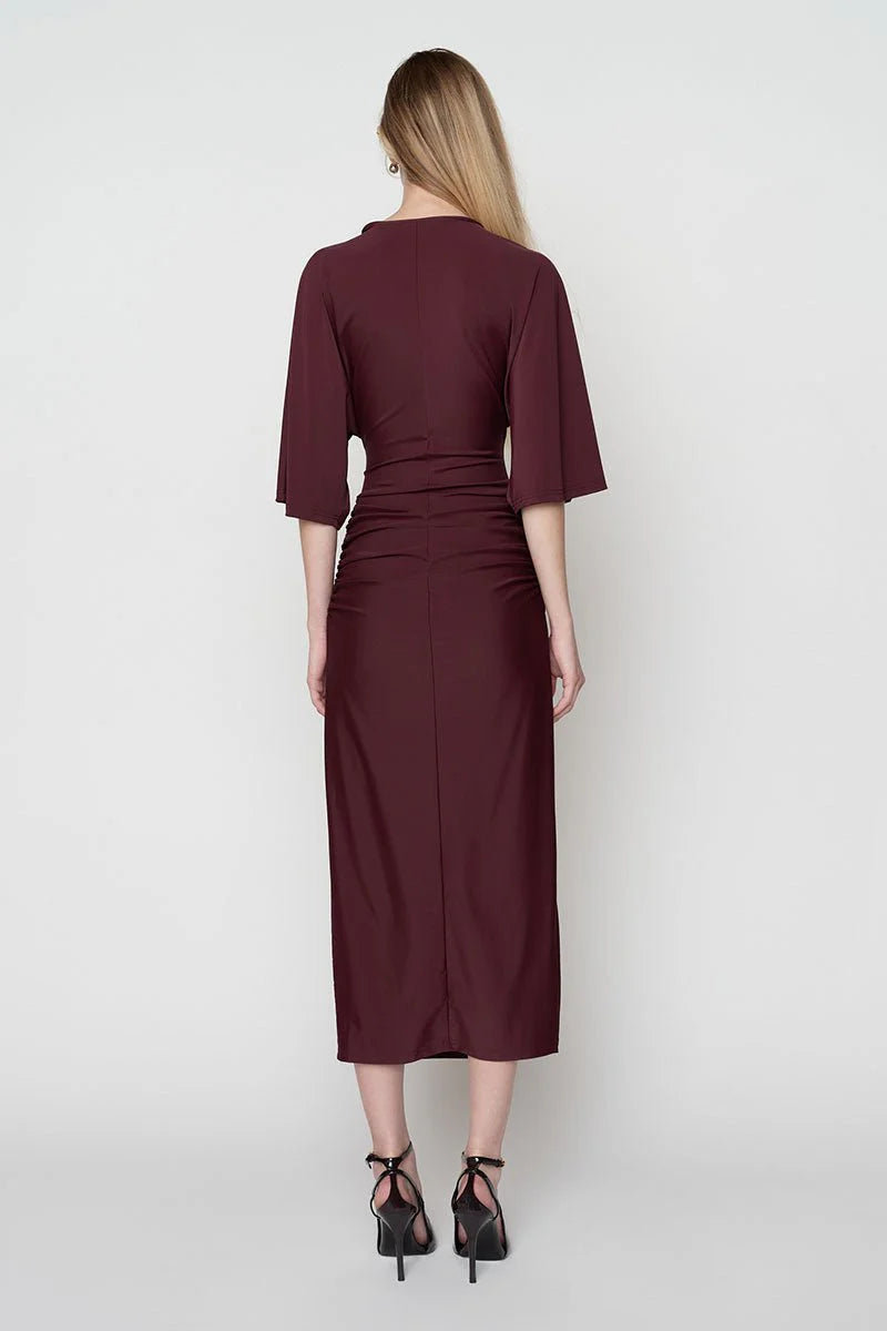 Woman wearing a burgundy dress with a plain white background