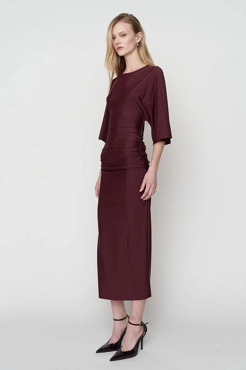 Woman wearing a burgundy dress on a white background