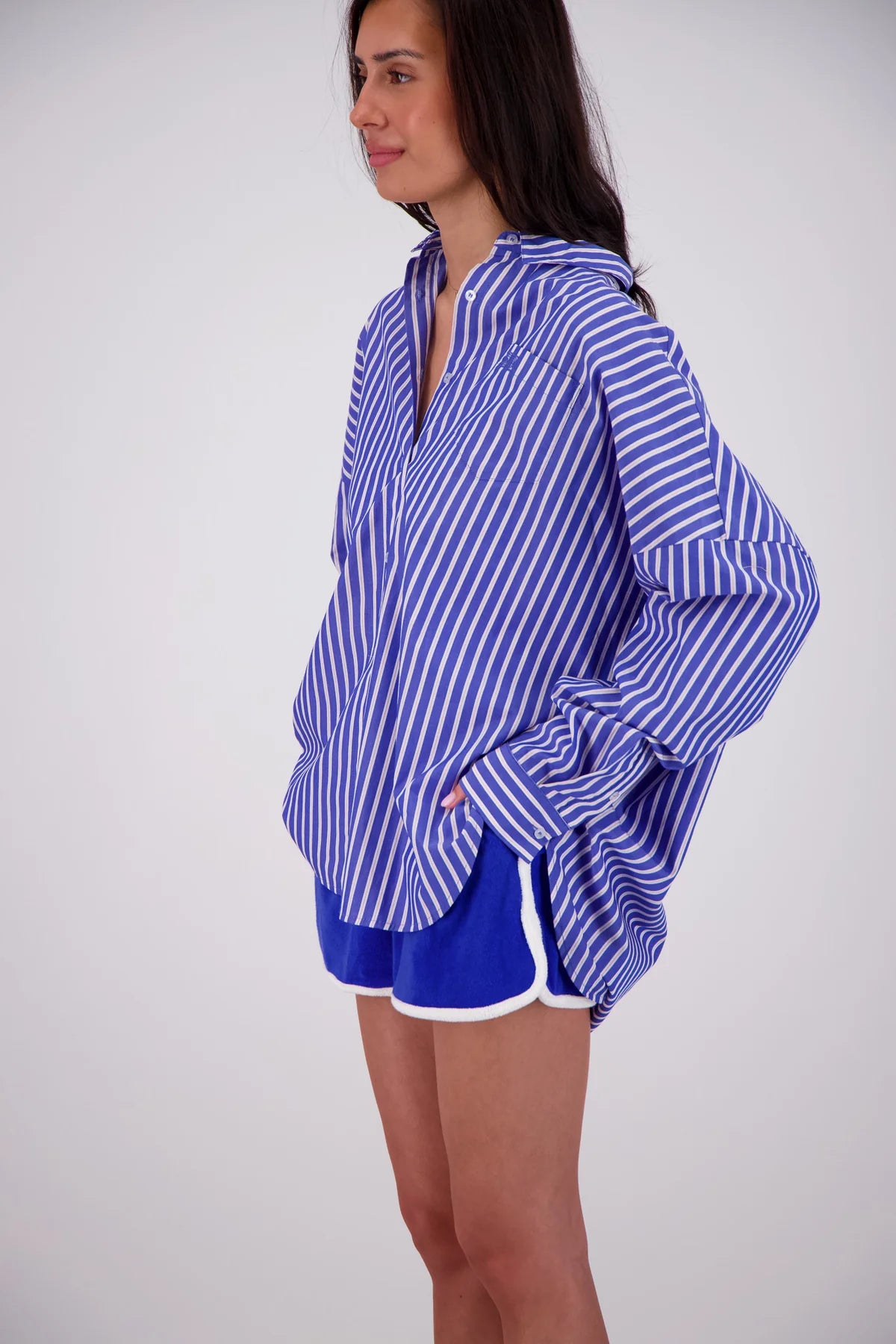 Woman wearing a blue and white striped shirt with matching shorts on a white background