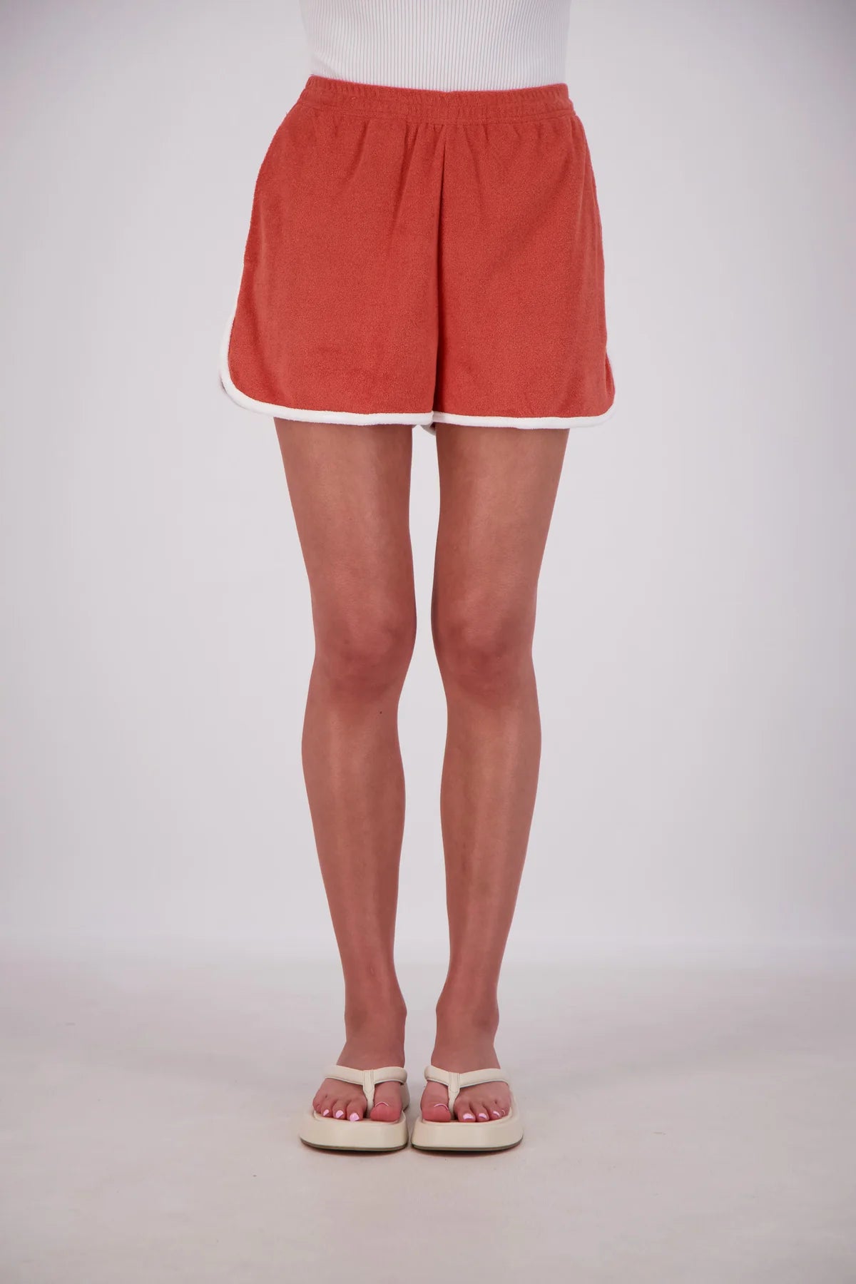 Person wearing red shorts on a white background
