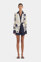 Woman wearing a floral patterned cardigan over a dress on a white background