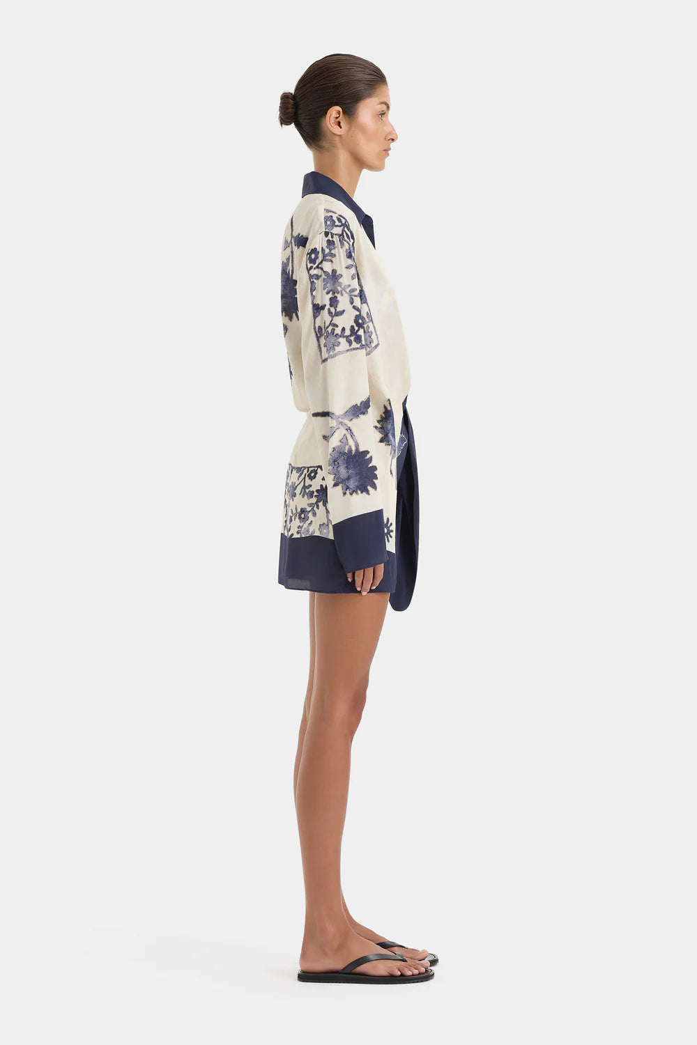 Woman wearing a floral dress and cardigan on a white background