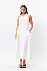 A woman standing in a white cotton day dress with pleat detail— a refined take on the classic shirt dress with timeless appeal.

Crafted from premium Australian cotton, this sleeveless midi features a structured collared neckline, racerback detail, and a fitted bodice that flows into a semi-flared A-line skirt. Stitch detailing at the fixed waist enhances the silhouette, while functional side pockets add everyday ease. Designed for the modern minimalist, this effortless style transitions seamlessly from day