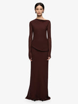 Woman wearing a long brown dress on a white background