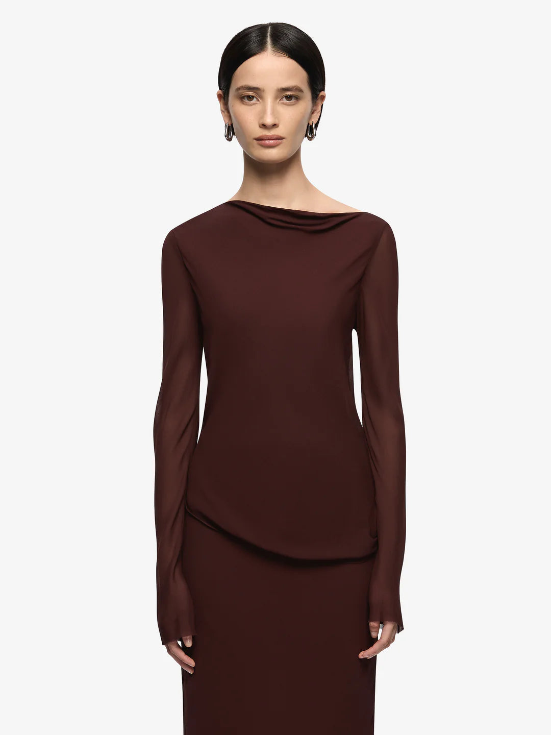 Woman wearing a brown long-sleeve top and skirt on a white background