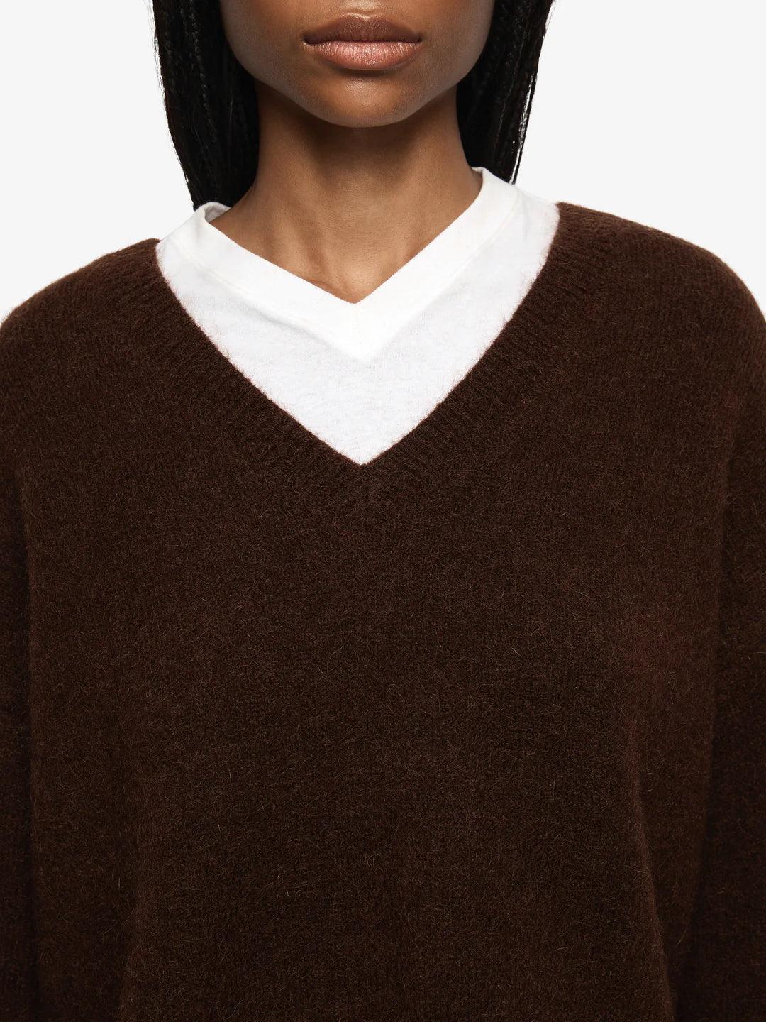 Brown sweater with a white collar worn by a person on a light gray background