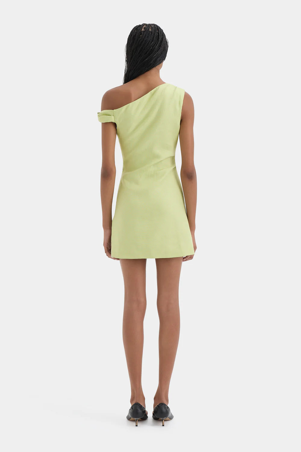 Woman wearing a light green one-shoulder dress on a white background