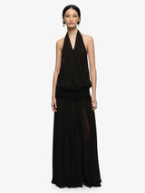 Woman wearing a black halter neck dress on a white background