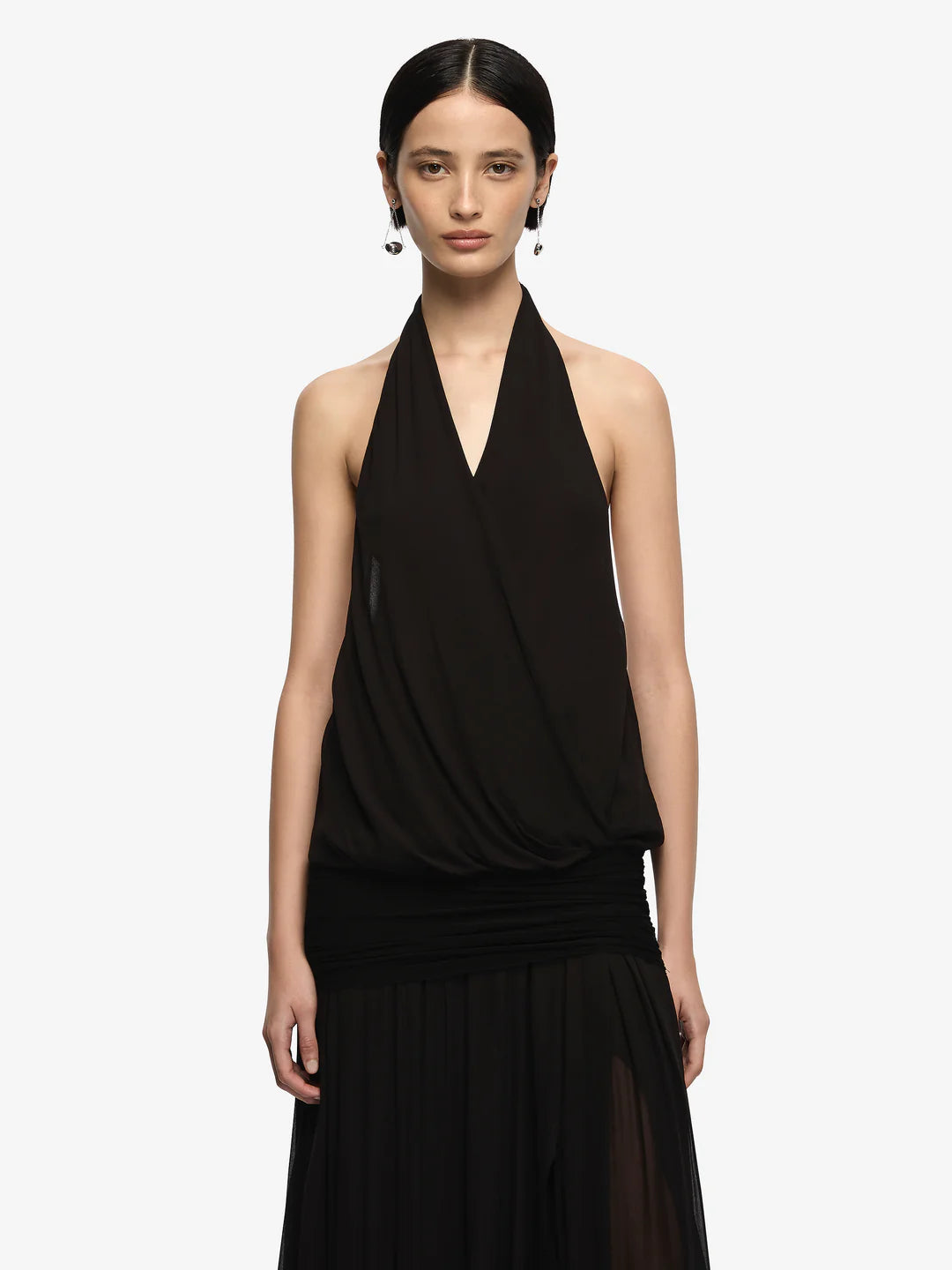Woman wearing a black halter neck dress on a white background