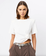 Woman wearing a white t-shirt and brown pants with a patterned belt on a white background