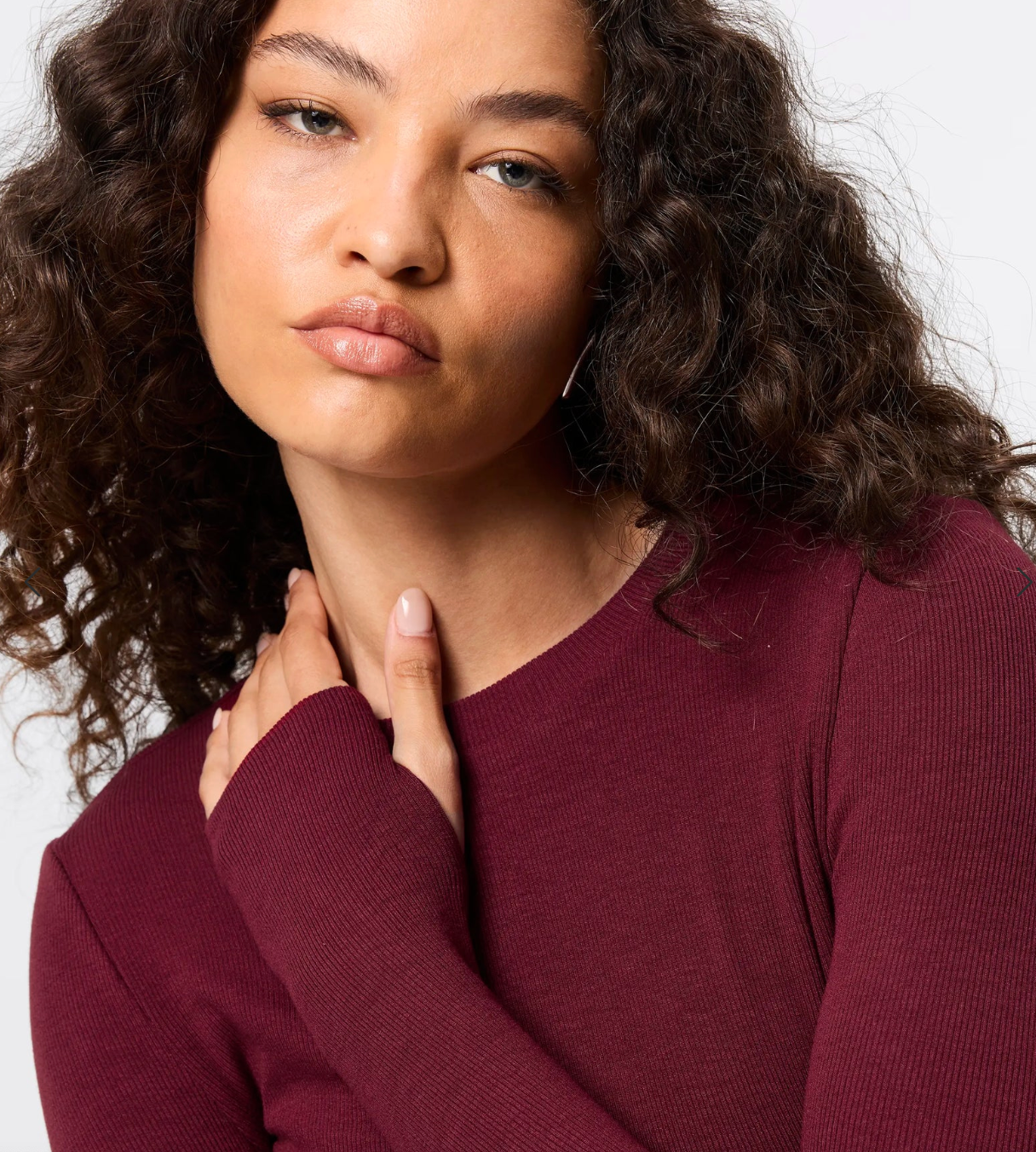 Woman wearing a maroon sweater against a plain background